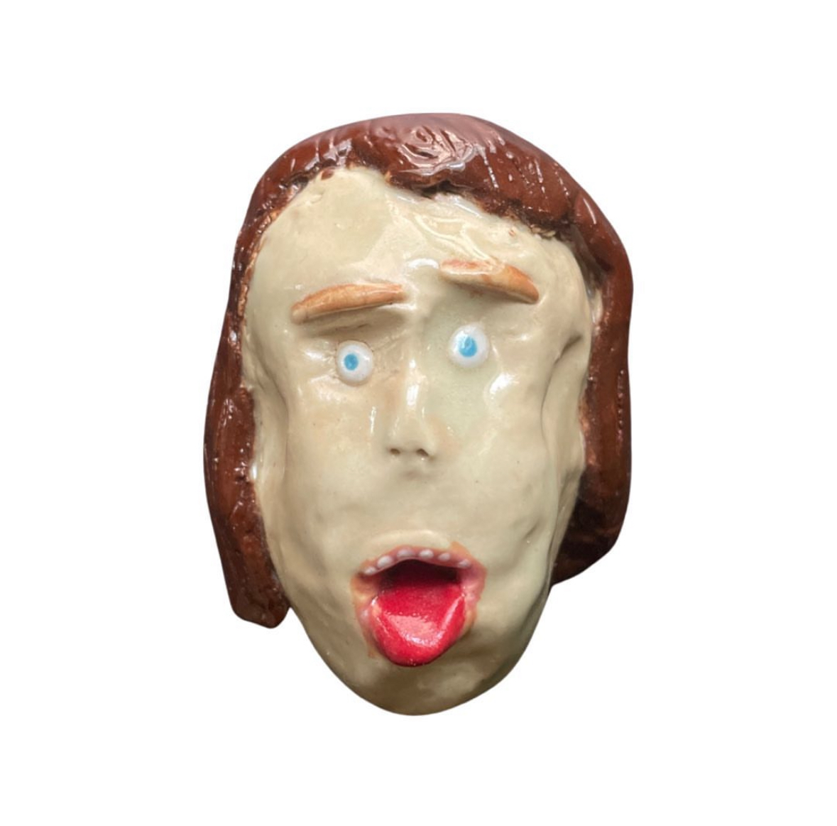 Ceramic woman head with brown hair sticking tongue out