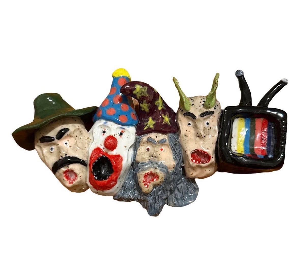 Ceramic wall sculpture with row of heads and small TV