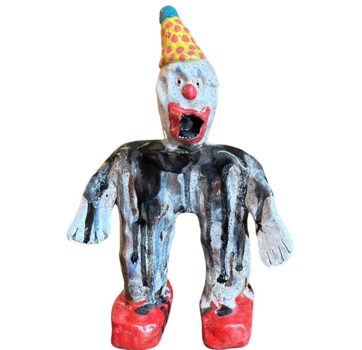 Ceramic screaming clown figure with yellow polka-dot hat, black striped outfit and red shoes