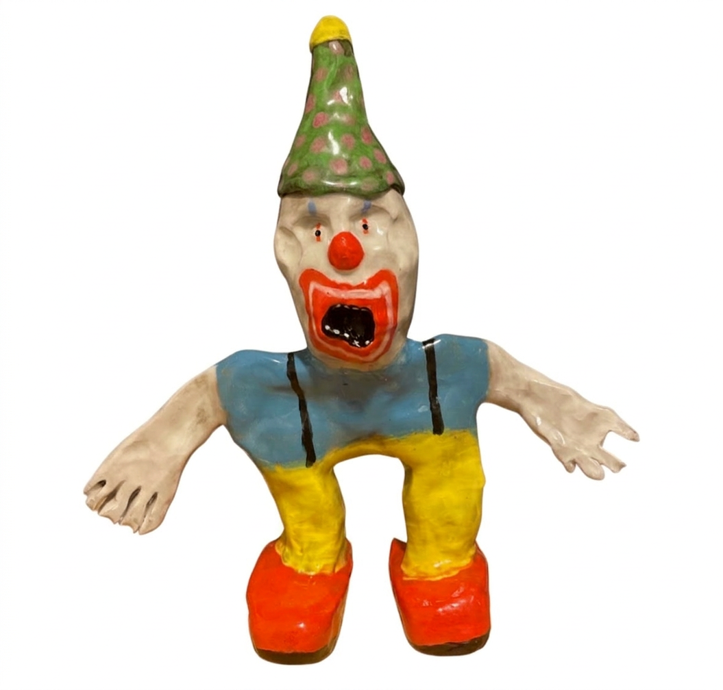 Ceramic screaming clown figure with green polka-dot hat, blue and yellow outfit and orange shoes