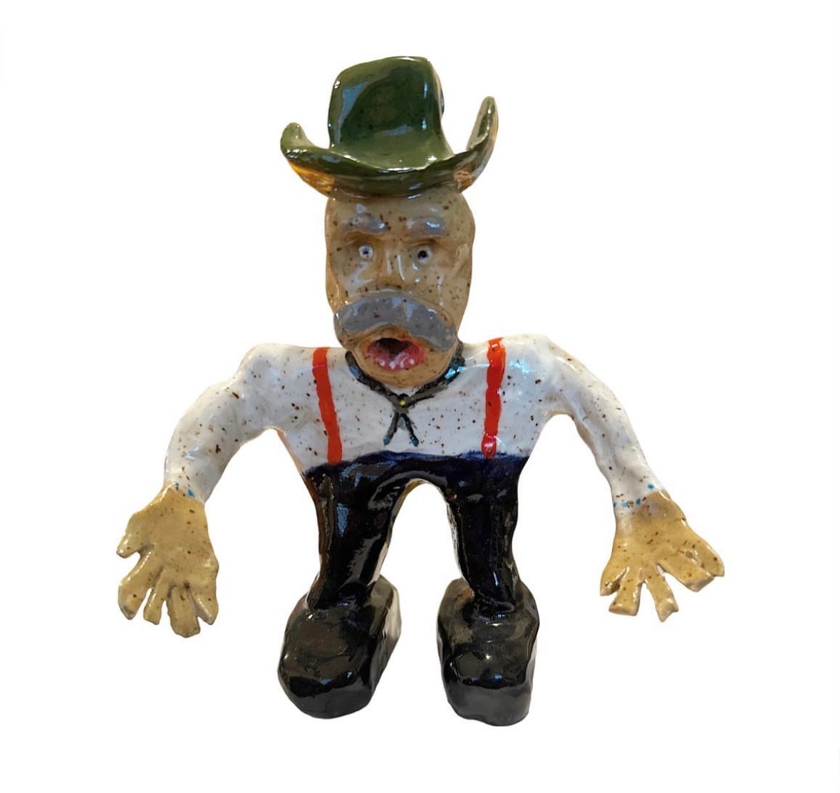 Ceramic cowboy figure with green hat, mustache, white shirt with red suspenders and black boots