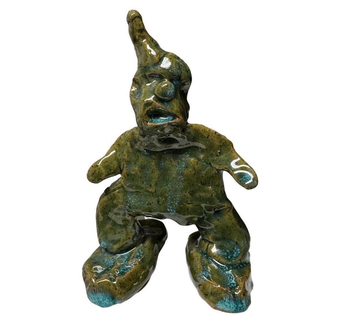 Ceramic green-glazed clown figure with pointed hat in crouching pose