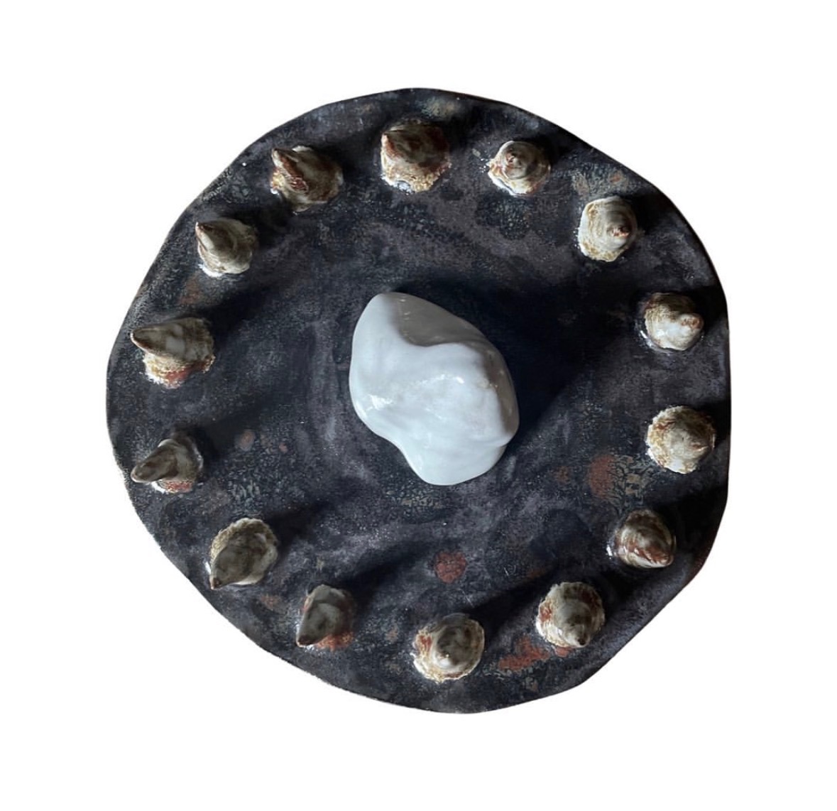 Ceramic landscape sculpture top-down view with ring of cones around a white stone