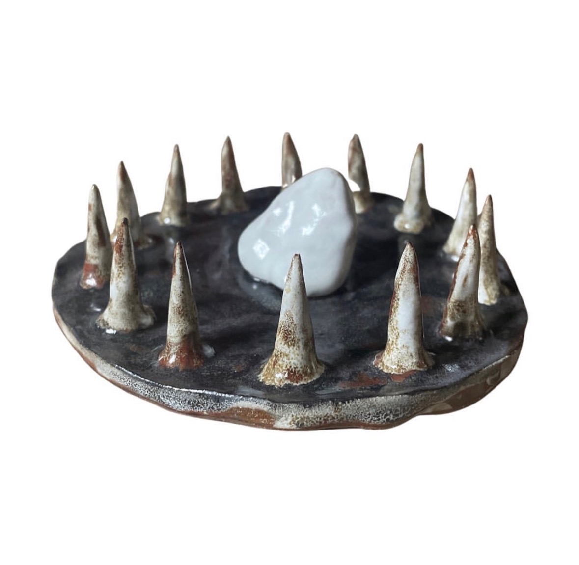 Ceramic landscape sculpture side view with ring of spiked cones surrounding a white stone