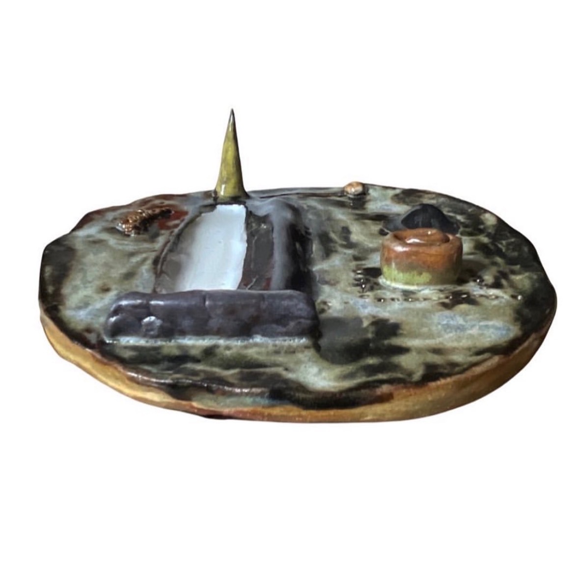 Ceramic landscape sculpture side view with green glaze, candle and small bowl