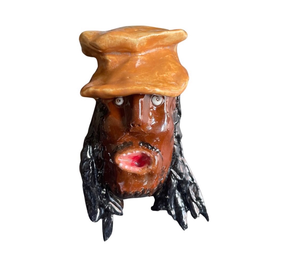 Ceramic brown head with long black hair, orange cap and small open red mouth