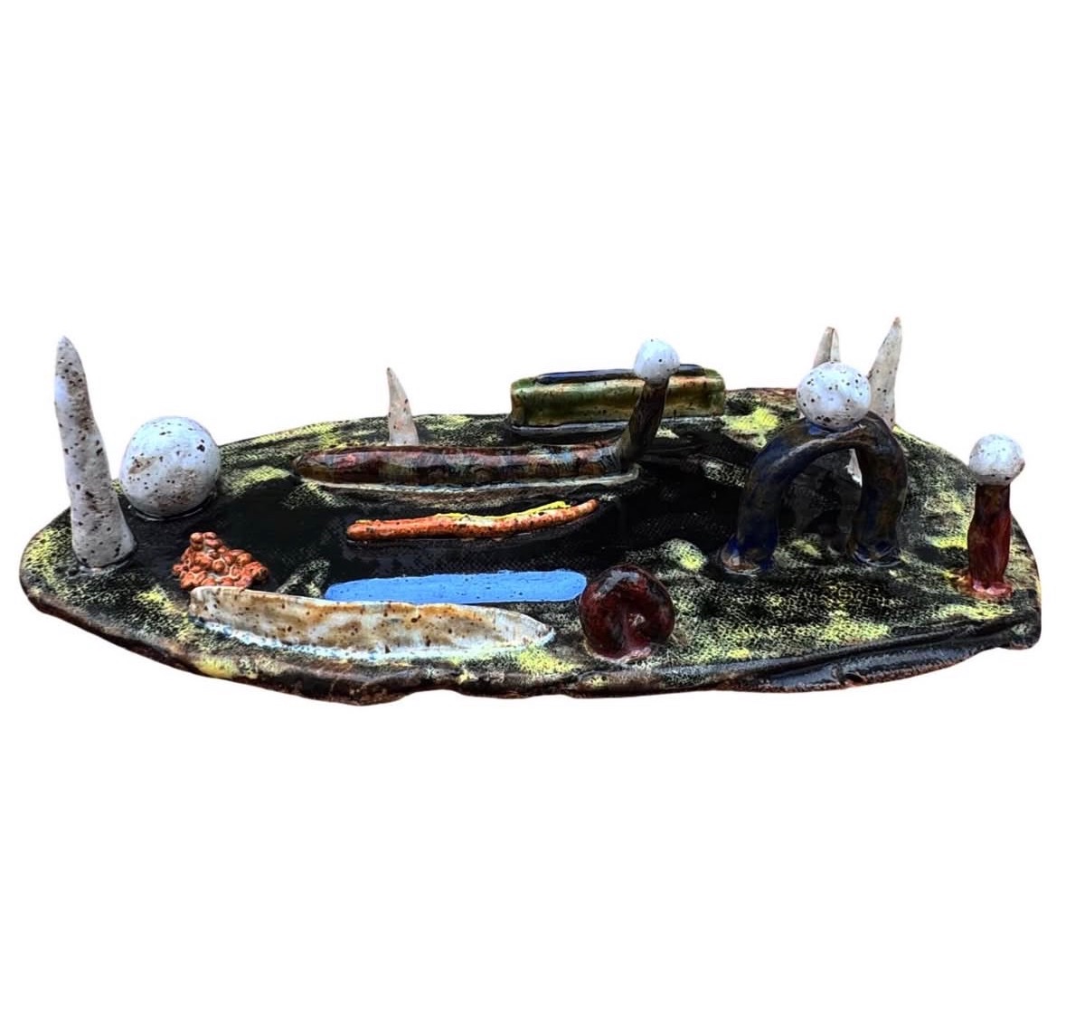 Ceramic landscape sculpture top-down view with spires, spheres, boat and colorful glazed elements