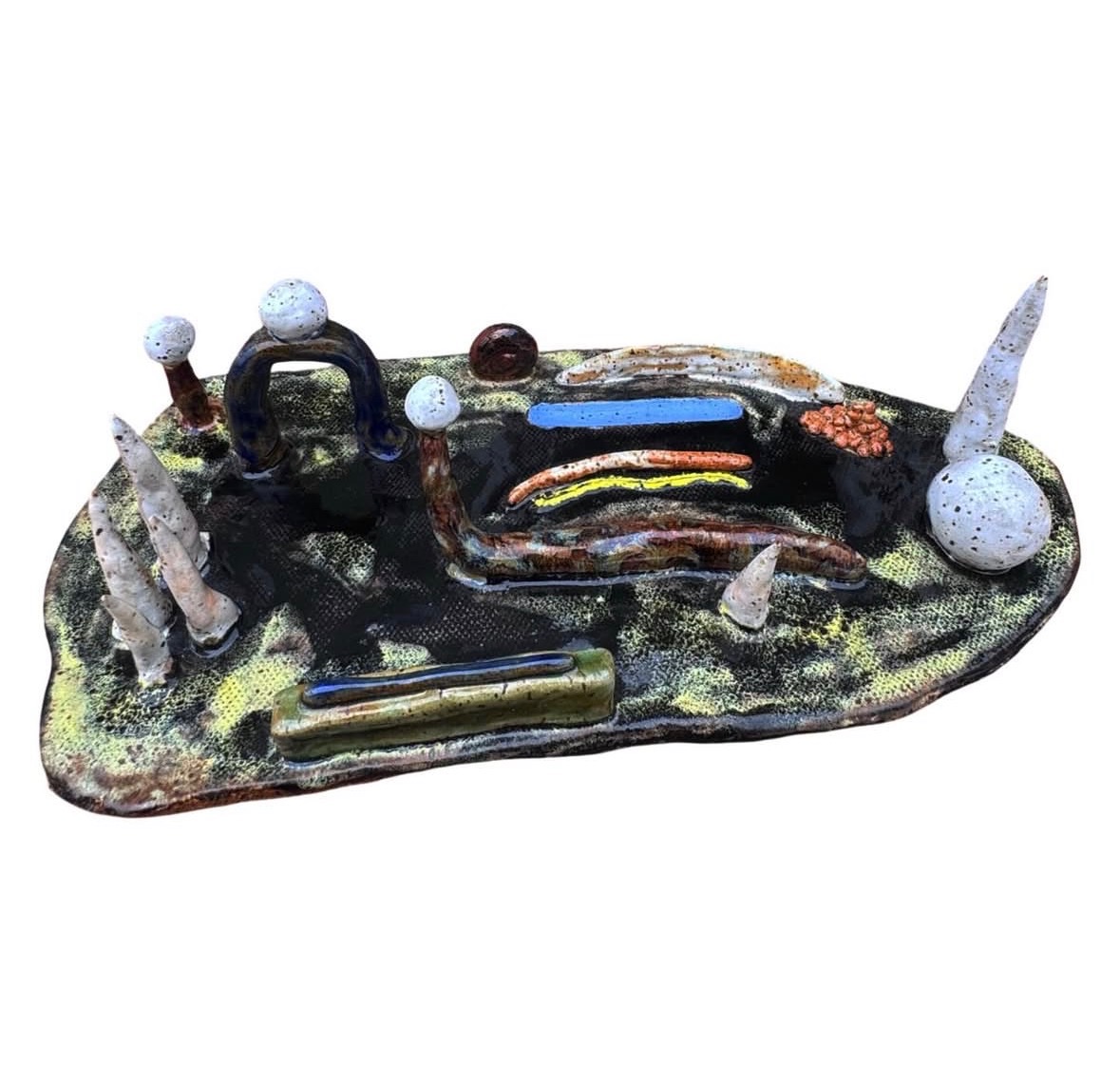 Ceramic landscape sculpture side view with spires, spheres, arched figures and colorful glaze elements