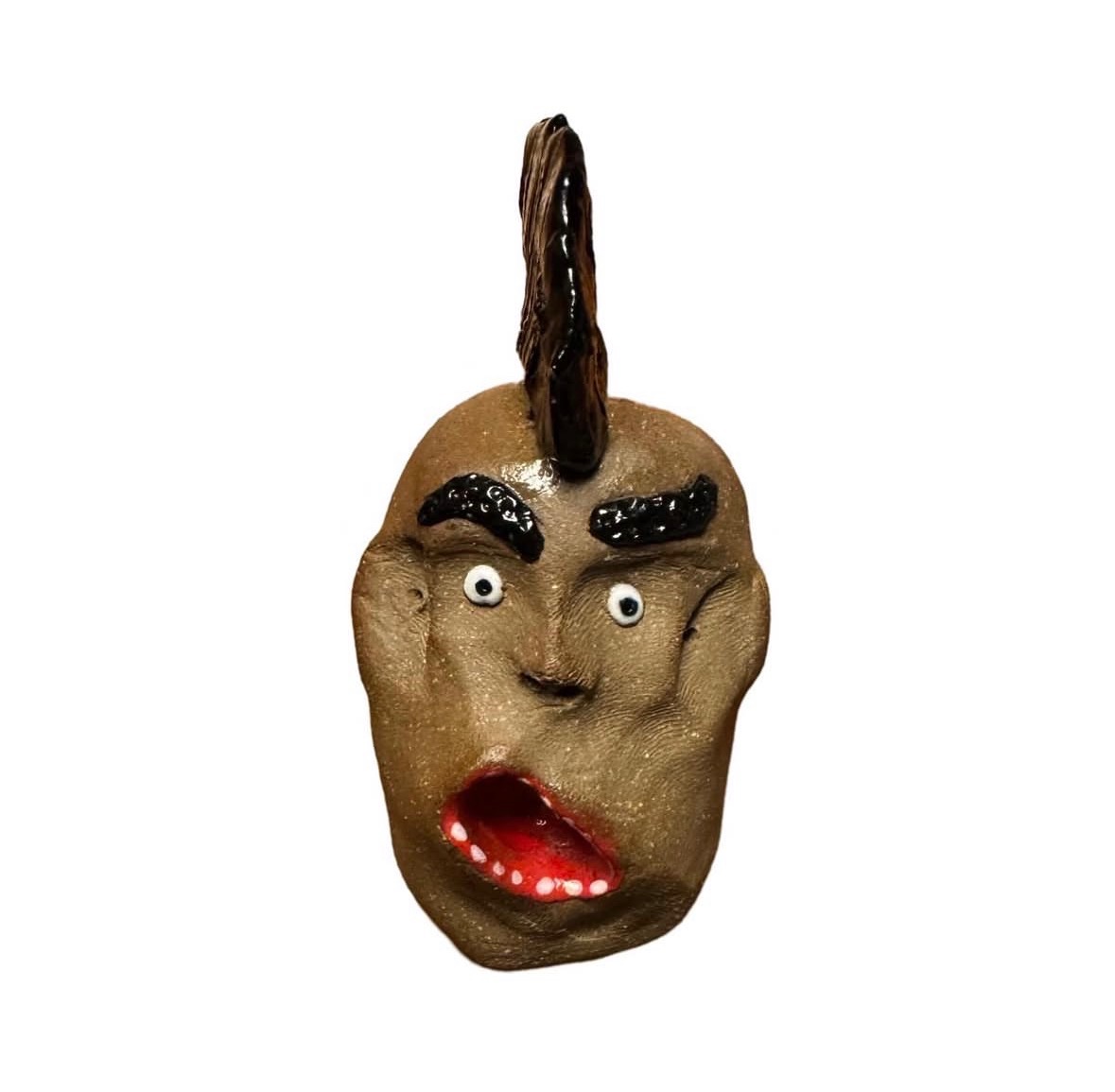 Ceramic brown head with tall black mohawk, dark eyebrows and open red mouth